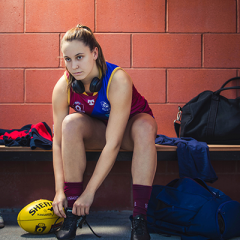 Natalie Grider in Brisbane Lions gera tying up shoelace 