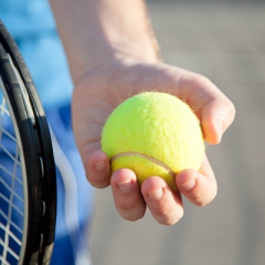 Person holding tennis ball in left hand