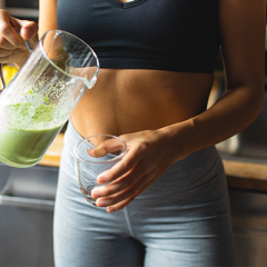 woman pouring green smoothie 
