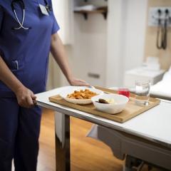 hospital food being delivered to patient in bed