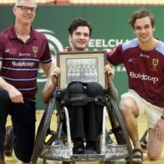 Conor Tweedy, with father Sean and brother Seamus, holds a photo of his grandfather's UQ Rugby premiership-winning side. Credit: Sportography